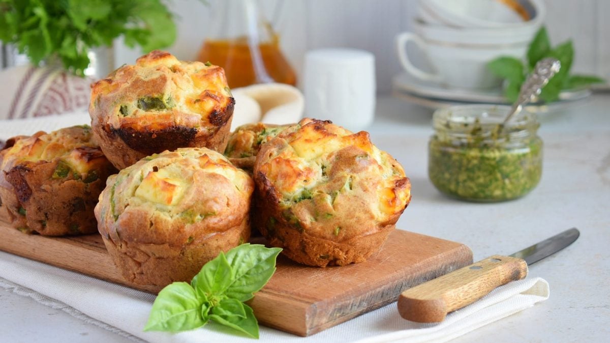 Ein paar Pesto-Muffins auf einem Holzbrett.