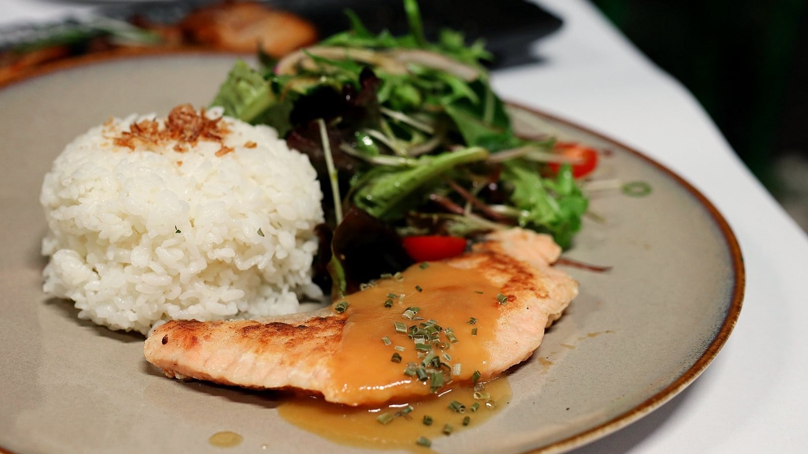 Ein Teller mit Lachs mit Misobutter und Reis