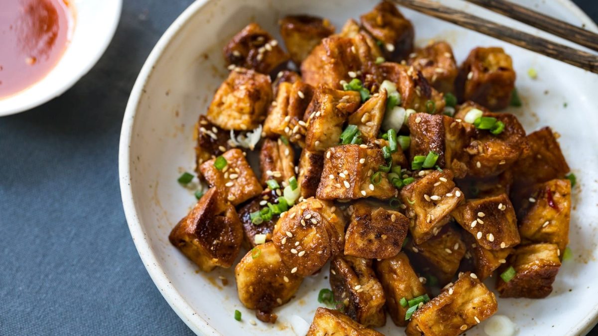 Ein Teller mit Popcorn Tofu auf einem grauen Untergrund.