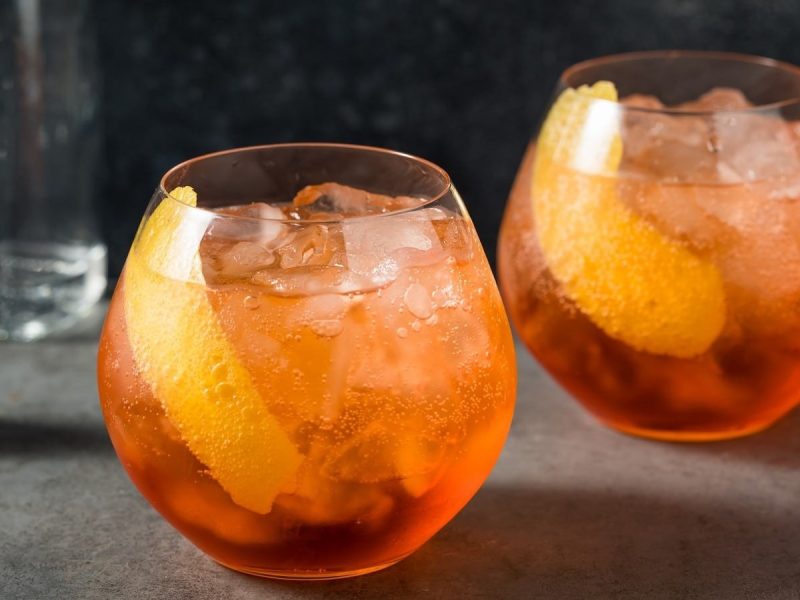 Zwei Gläser Tequila Spritz auf einem grauen Tisch.
