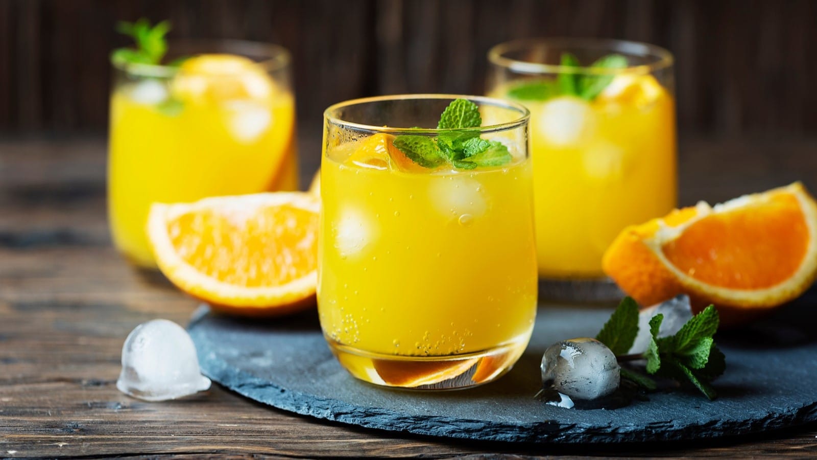 Drei Gläser Soju Fizz auf einem Schiefertablett.