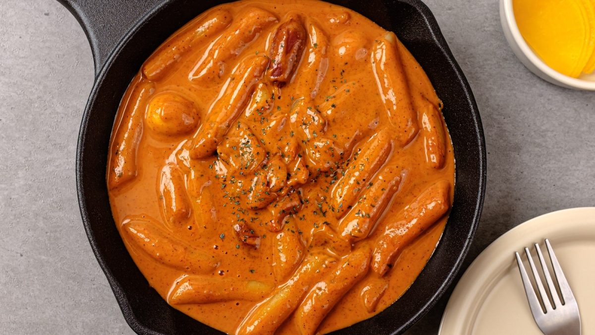 Eine schwarze Pfanne mit Rose Tteokbokki darin.