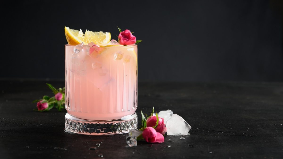 Ein Glas Lemon Sarti Spritz vor einem schwarzen Hintergrund.