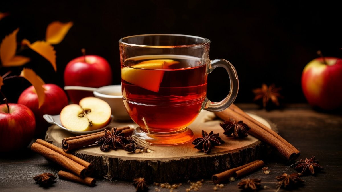 Eine Tasse Früchtetee neben frischem Obst.