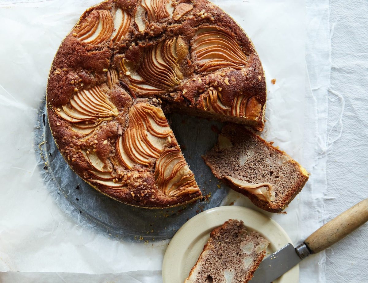 Ein Birnen-Haselnuss-Kuchen in der Draufsicht, ein Stück ist herausgeschnitten, das Rezept stammt aus dem Backbuch "Naschmittag".