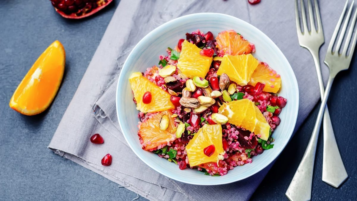 Eine Quinoa-Bowl mit Orangen und Rote Bete in einer hellblauen Schüssel.