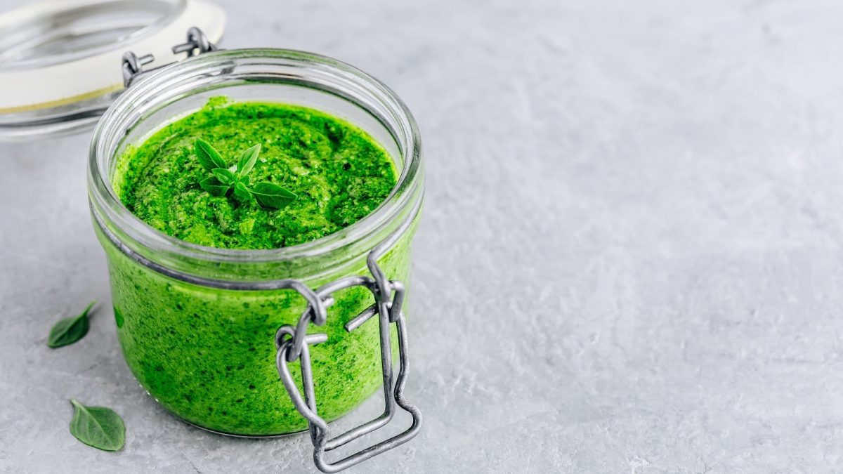 Ein Glas Salbei-Pesto auf einem grauen Untergrund.