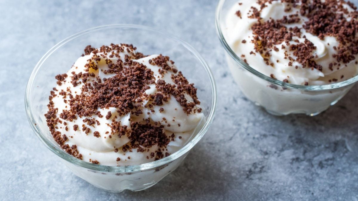 Maulwurfs-Dessert: Eine Schale gefüllt mit einer Quark-Joghurt-Mischung mit Banane und Kekskrümel auf marmoriertem Untergrund.