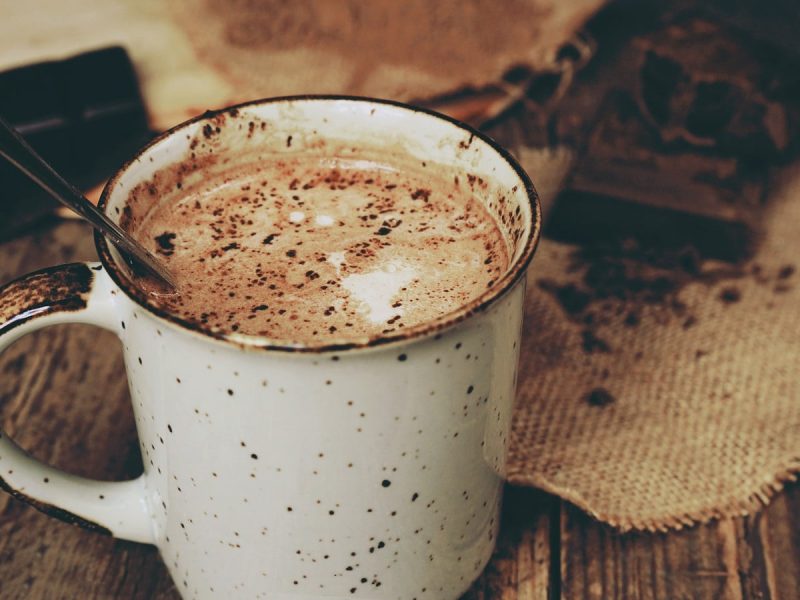 Eine Tasse heiße Milchmädchen-Schokolade auf einem Holztisch.