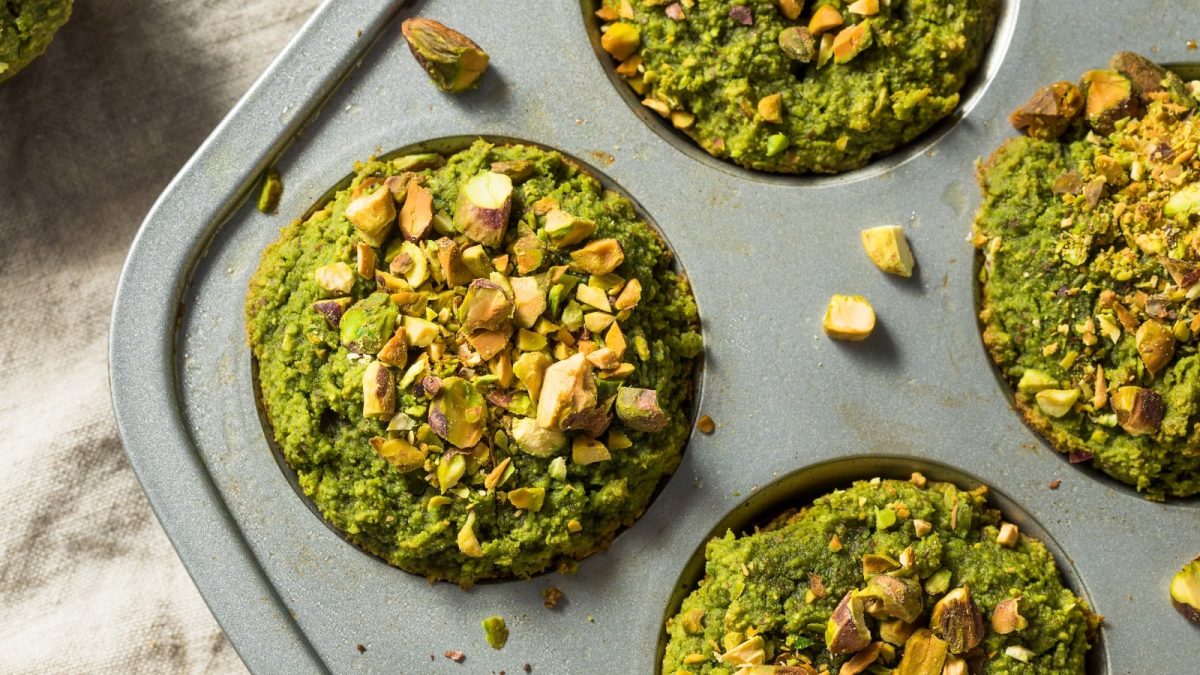 Eine Muffinform mit Matcha-Pistazien-Muffins