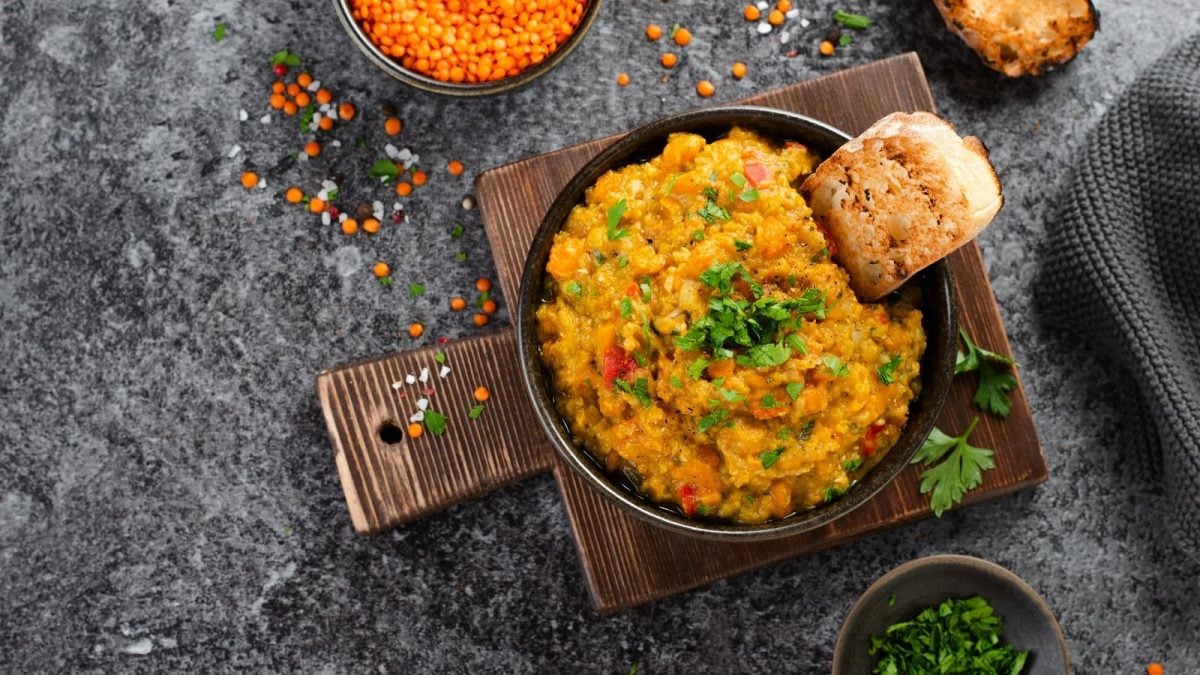 Eine Schüssel Kokos-Dhal auf einem Holzbrett.