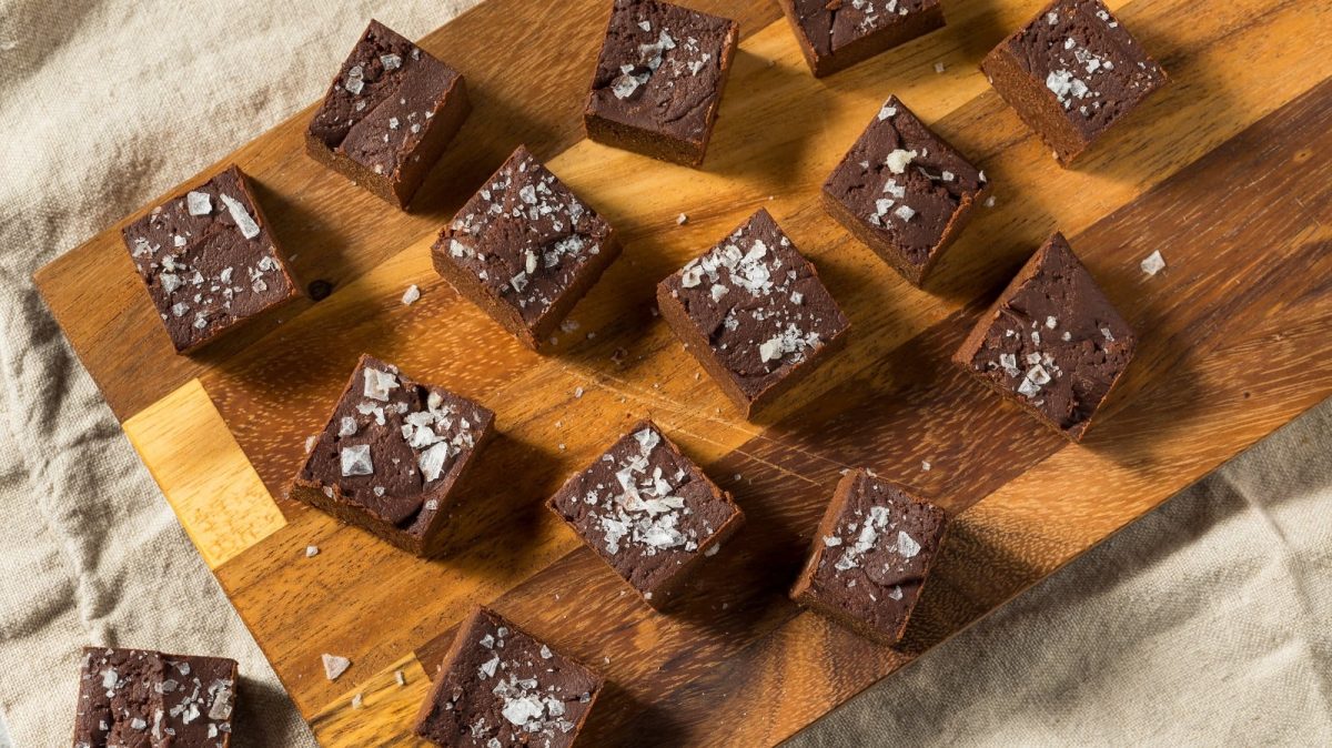 Ein Holzbrett mit Schoko-Süßkartoffel-Fudge auf einem beigen Tuch.