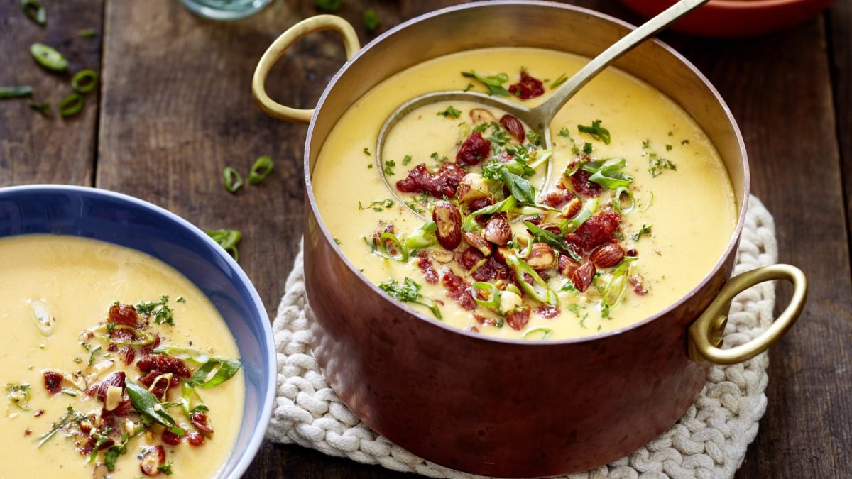 Zwei Portionen Fondue-Eintopf mit Chorizo auf einem braunen Holztisch.