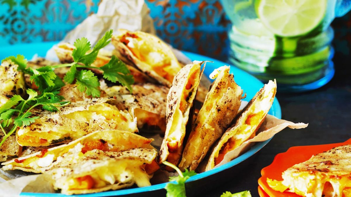 Ein türkiser Teller mit Quesadillas mit Kürbis.