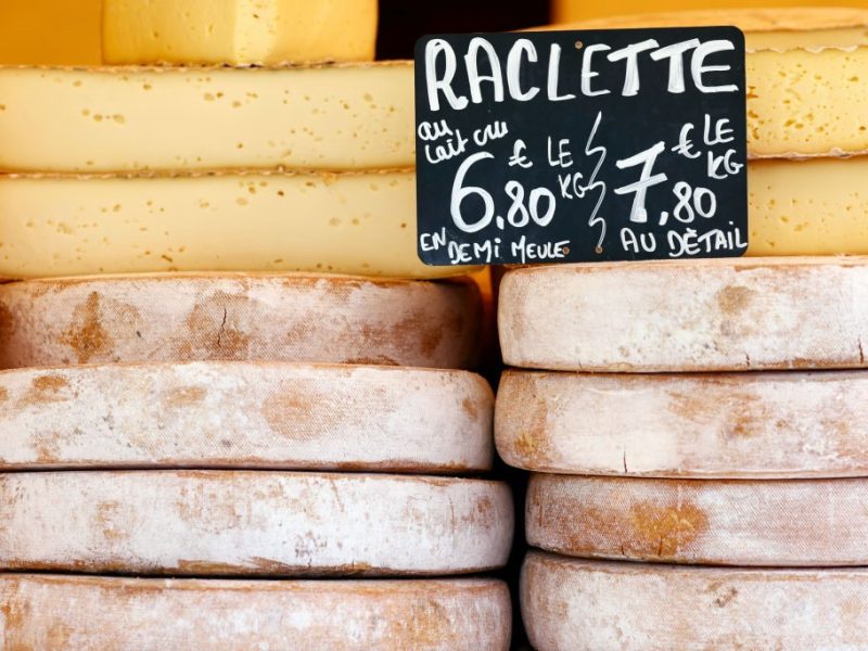 Mehrere Raclettekäse im Schaufenster eines französischen Ladens.