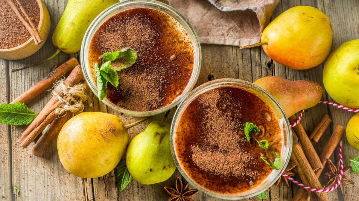 Zwei Gläser Chai-Birnen-Smoothie auf einem Holztisch.