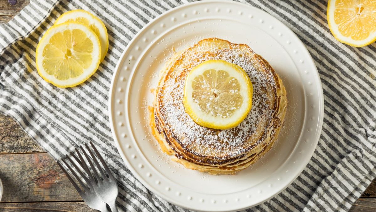 Ricotta-Zitronen-Pancakes auf einem gestreiften Tuch.