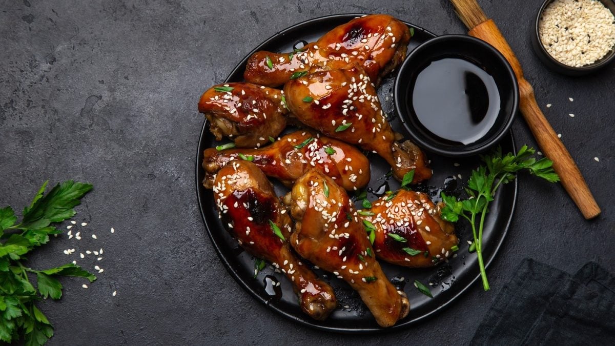Ein schwarzer Teller mit Soy Sauce Chicken auf einem grauen Tisch.