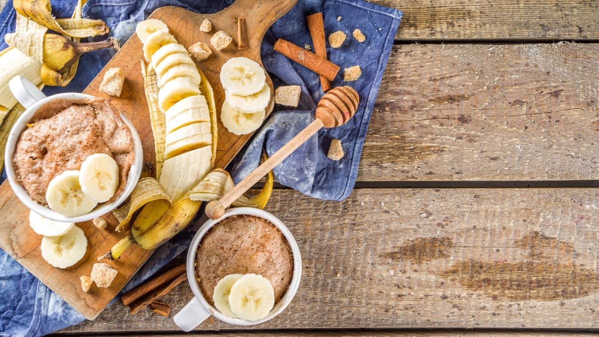 Zwei Bananenbrot Mug Cakes auf einem Holztisch.