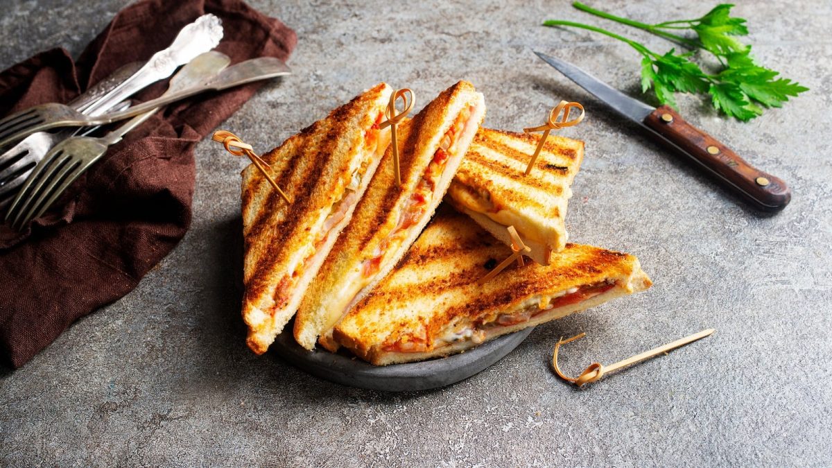 Prosciutto Grilled Cheese auf einem grauen Untergrund.