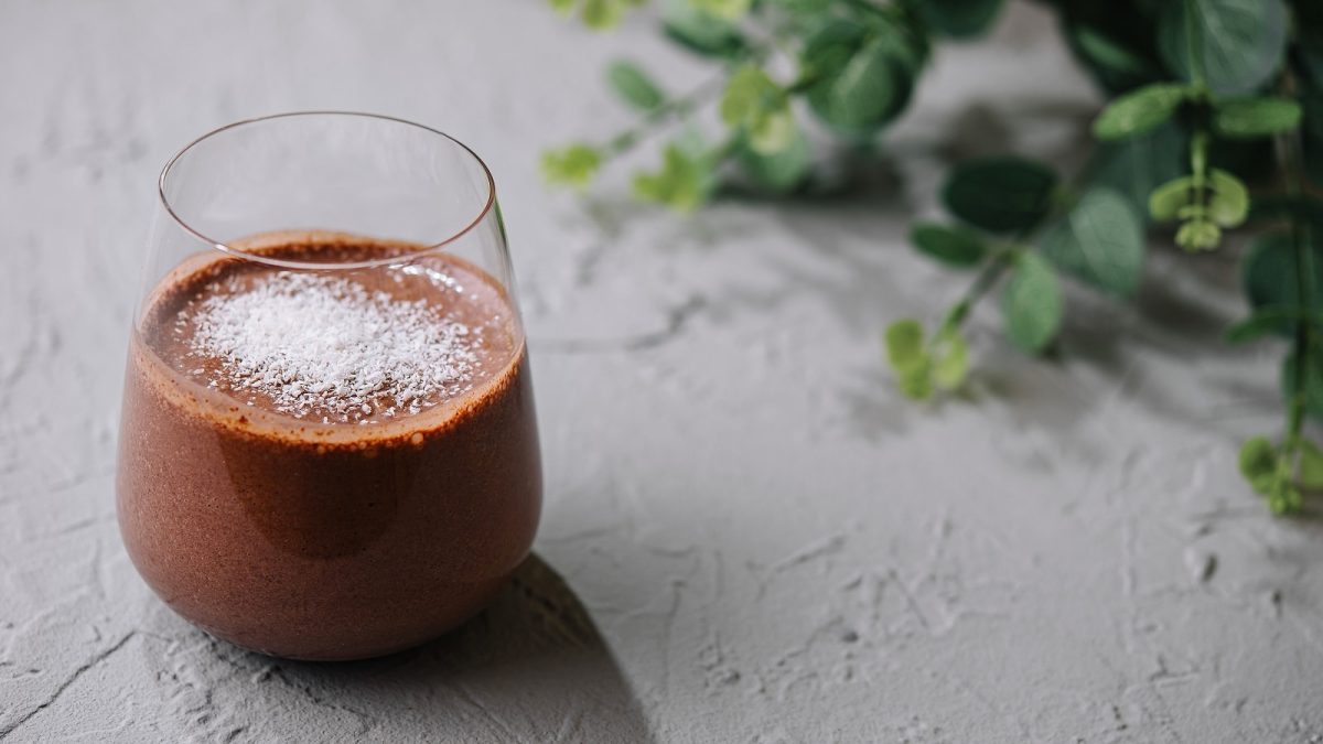 Ein Glas Choco Coco Smoothie auf einem grauen Tisch.