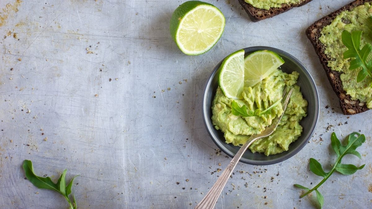 Eine Schüssel Rosenkohl-Guacamole auf einem grauen Untergrund.