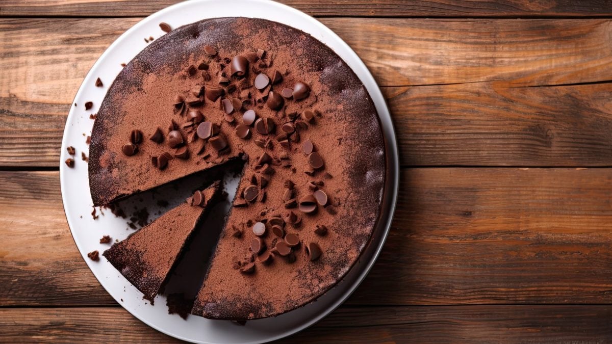 Glutenfreier Schokokuchen auf einem weißen Teller. Der Hintergrund ist aus Holz.