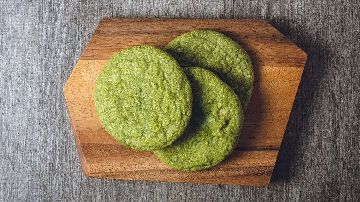 Matcha-Cookies auf einem hölzernen Brett. Der Hintergrund ist grau.