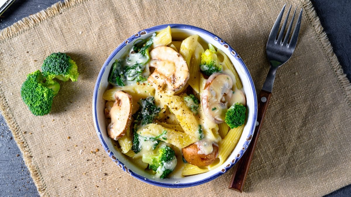 Draufsicht: Eine Schale One-Pot-Pasta mit Brokkoli auf einem groben Leinentuch auf einem Tisch-