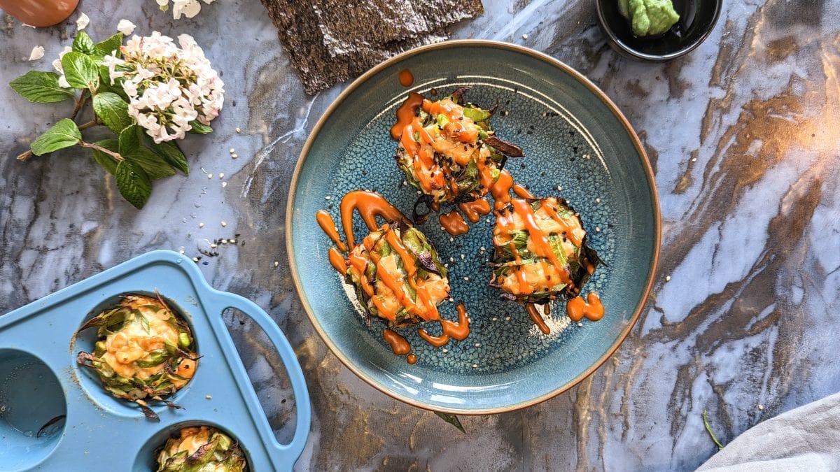 Die Sushi-Muffins von auf blauem Teller und grauem Marmortisch. Alles direkt von oben fotografiert.