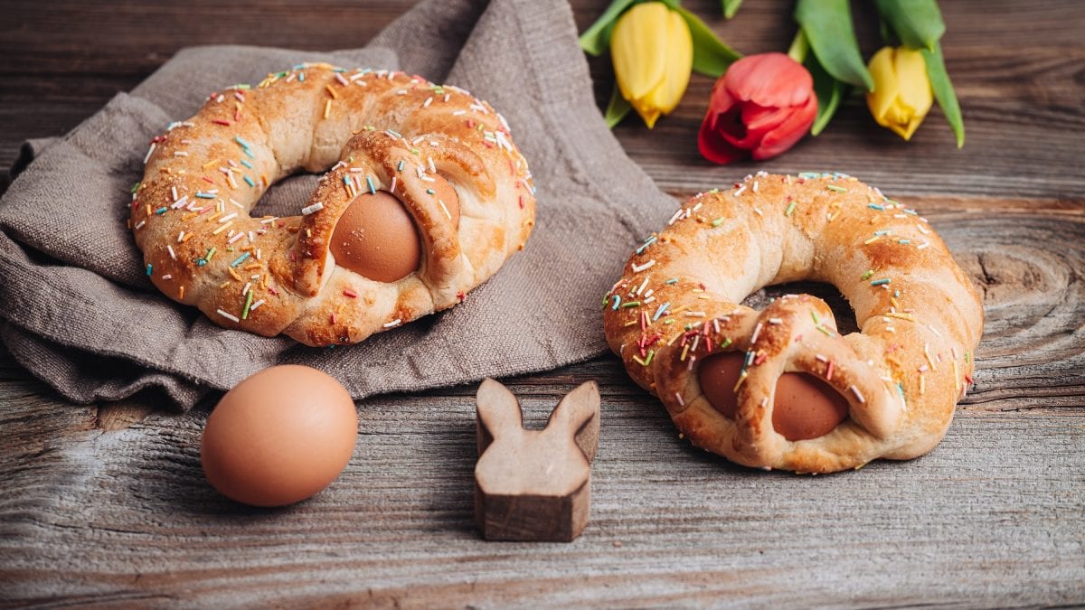 Scarcelle pugliesi auf einem grauen Tuch. Davor ein braunes Ei und ein Holzosterhase. Im Hintergrund Tulpen.