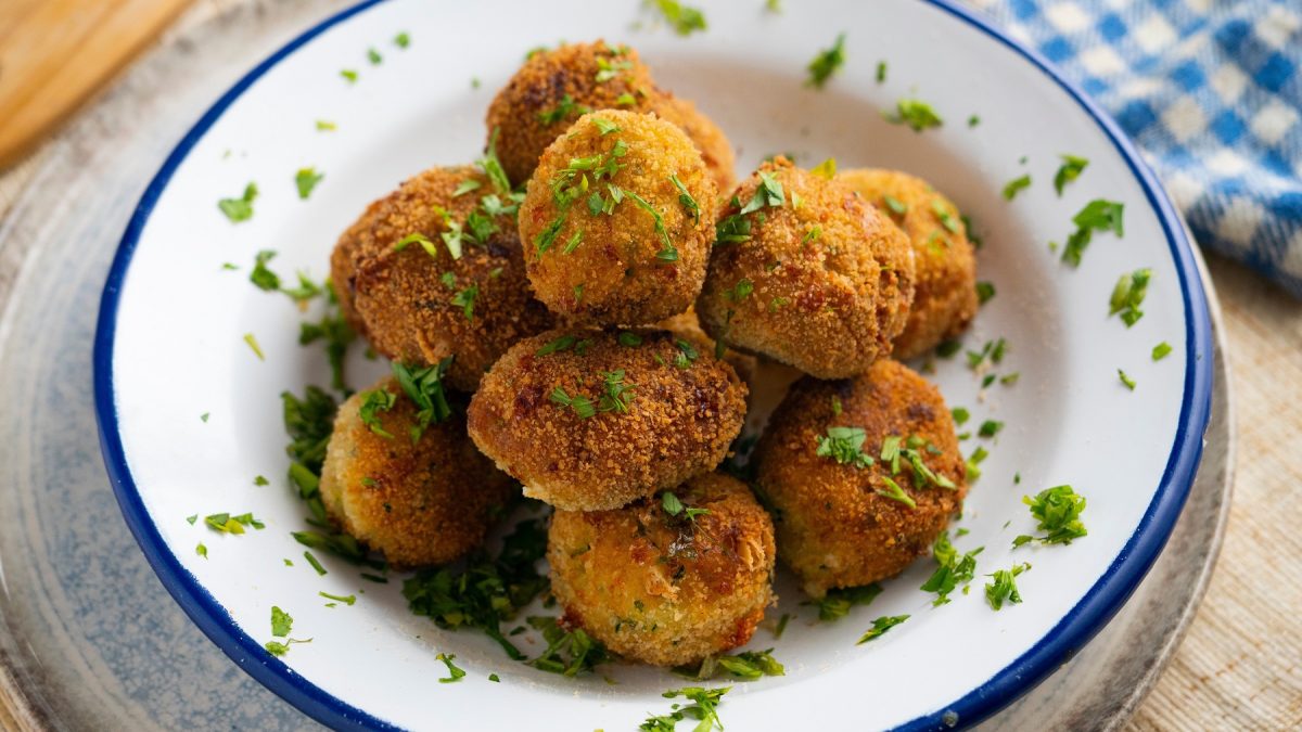 Brokkoli-Kroketten auf einem weißen Teller mit Petersilie.