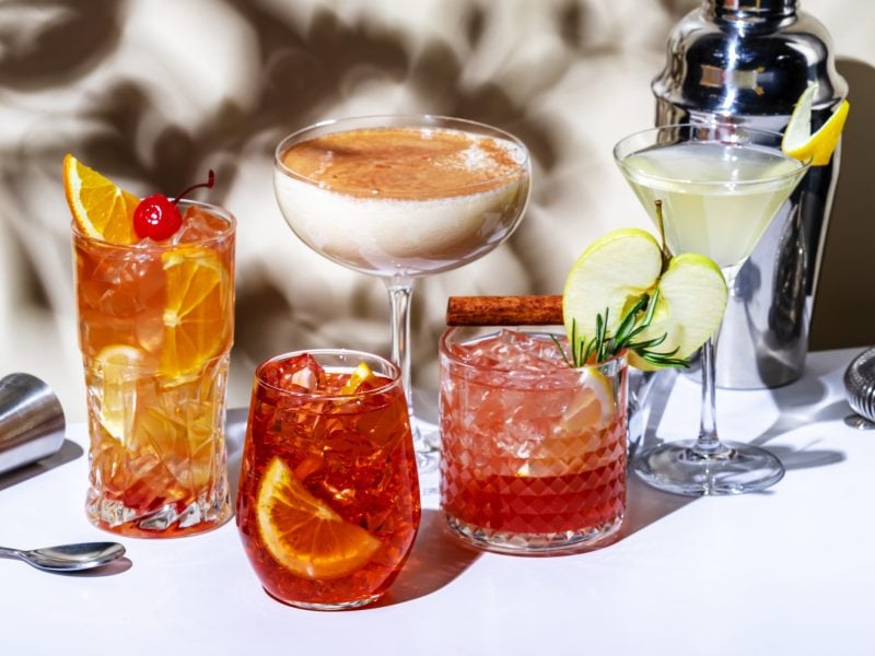 Cocktails verschiedene Sorten auf einem weiße Tisch in Frontalansicht.