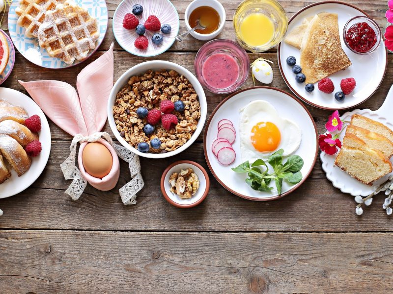 Österliches, festliches Frühstück oder Brunch, serviert auf einem rustikalen Holztisch