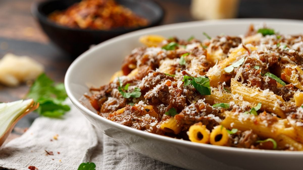Pasta alla genovese auf einem weißen Teller mit Parmesan und Petersilie. Als Nahaufnahme fotografiert.