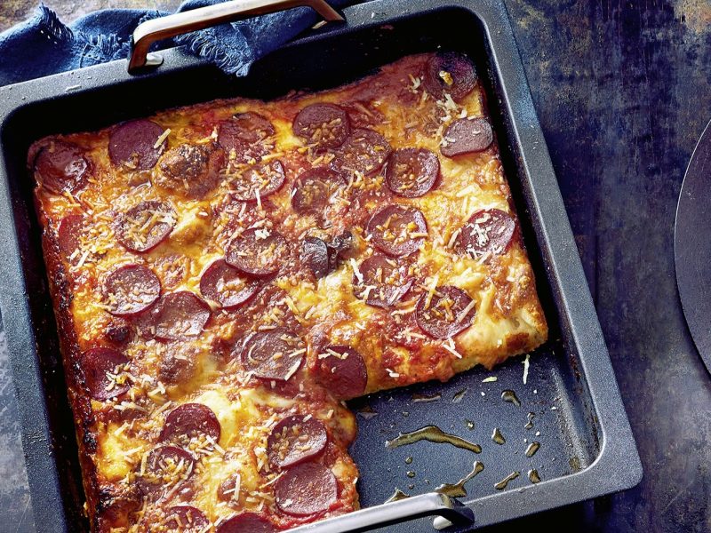 Ein Backblech mit der Detroiz Pizza auf einem dunklen Untergrund direkt von oben fotografiert.