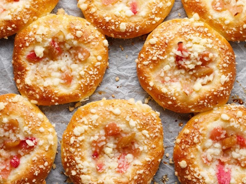 Rhabarber-Brötchen mit Streuseln auf Backpapier.