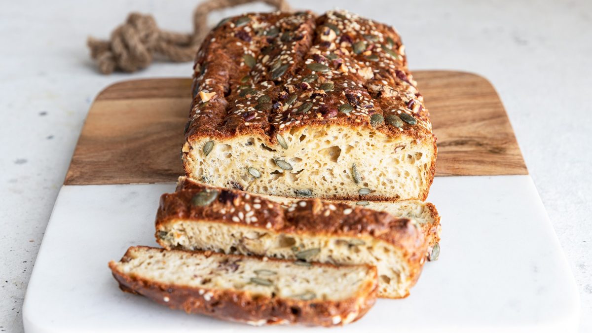 Angeschnittenes Tahini-Brot von vorne fotografiert auf einem Holzbrett.