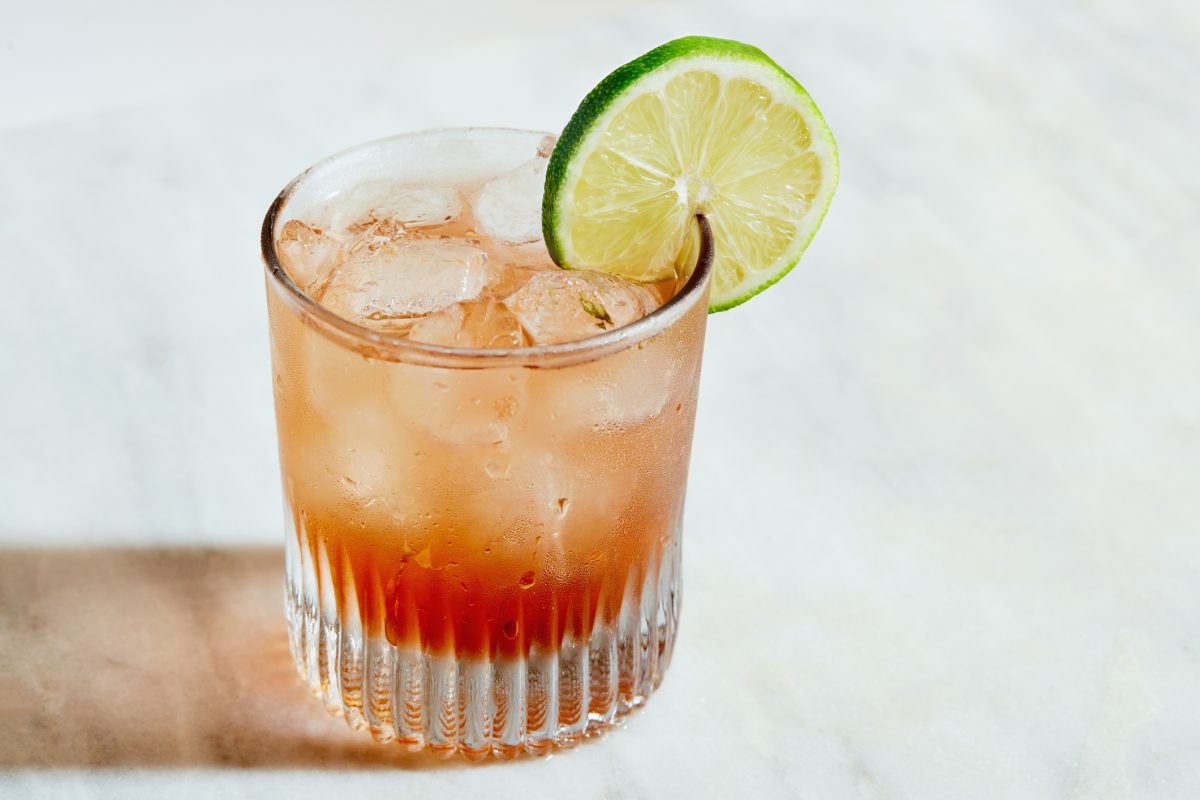Amaro Spritz in einem Glas mit Limettenscheibe und Eis.