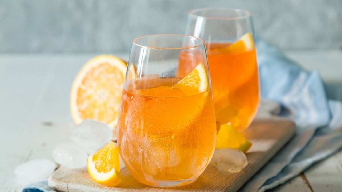 Aperol Soda in zwei Gläser vor einem hellen Hintergrund.