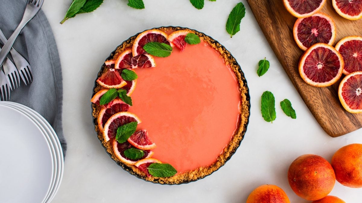 Draufsicht von Aperol Spritz Tarte dekoriert mit Blutorangen.