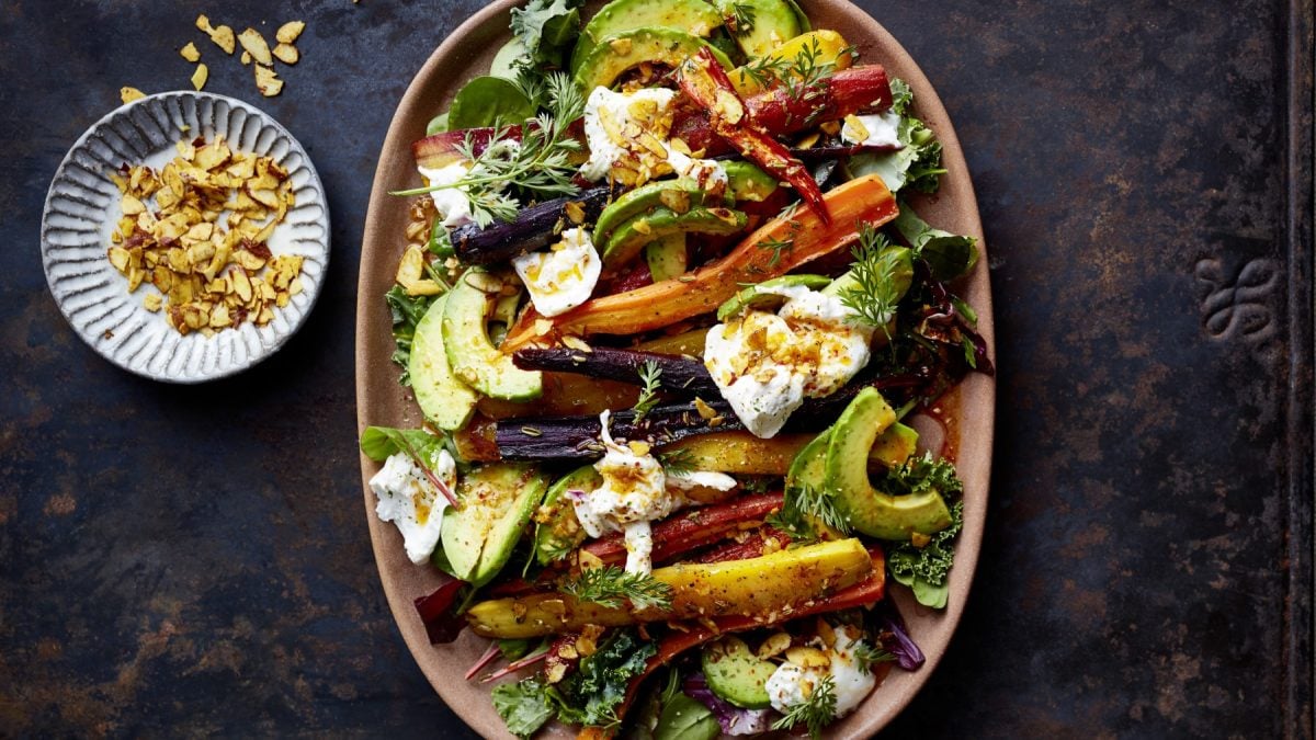 Draufsicht: Indian-Summer-Röstmöhren mit Avocado und Burrata angerichtet auf einem großen Teller