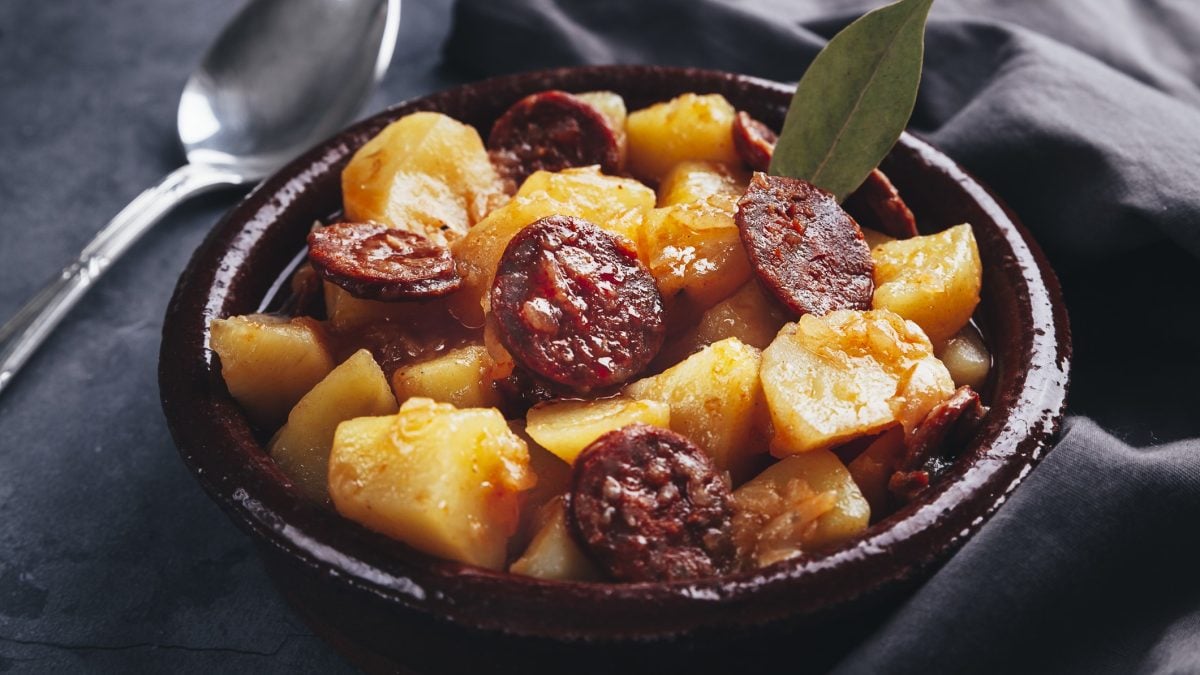 Patatas a la riojana in einer Schale mit einem getrockneten Lorbeerblatt.