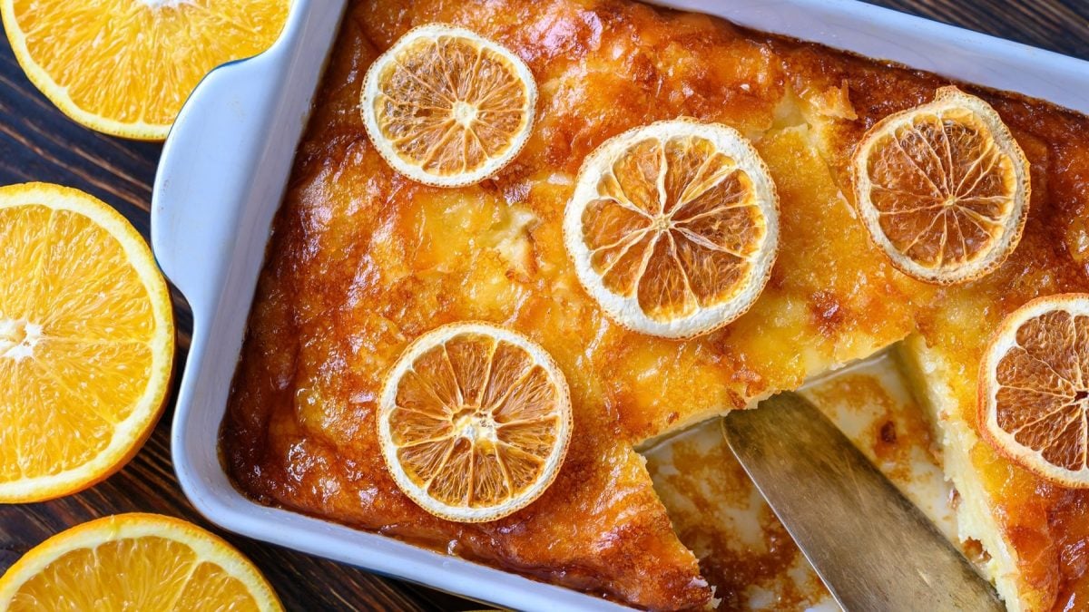 Portokalopita mit Orangenscheiben dekoriert in einer Auflaufform.