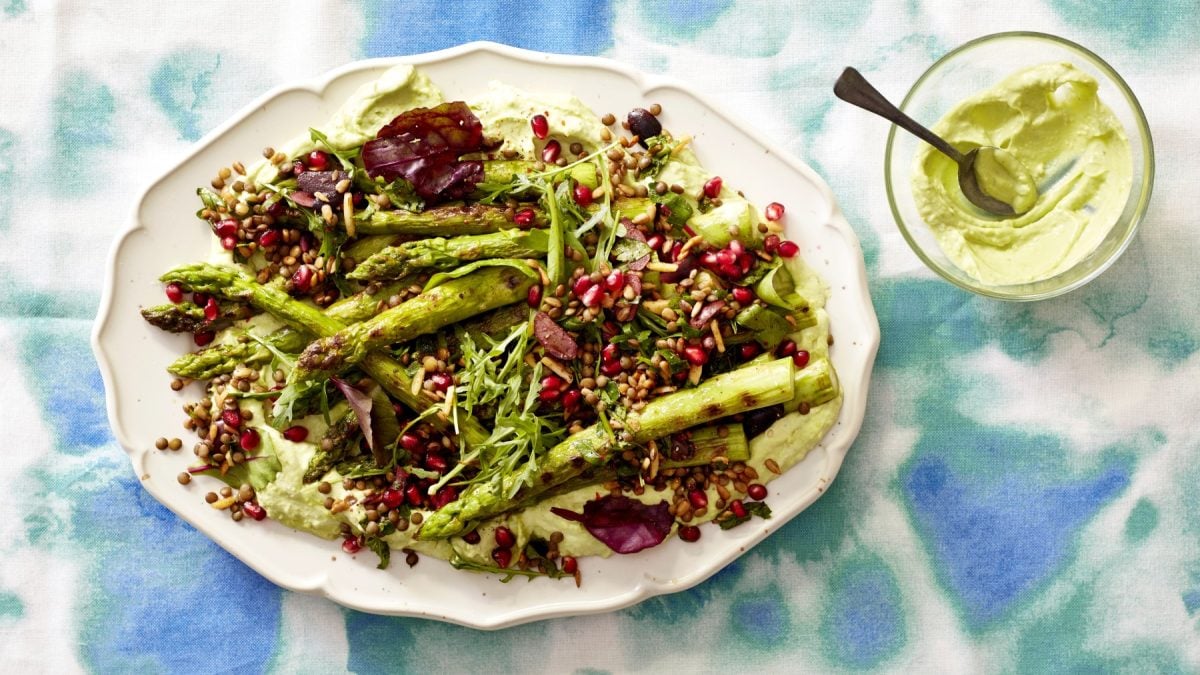 Spargel-Berglinsen-Tohuwabohu auf Avo-Mousse auf einer weißen Platte auf blau/weißem Hintergrund. Rechts oben ein Schüsselchen mit Avocado.