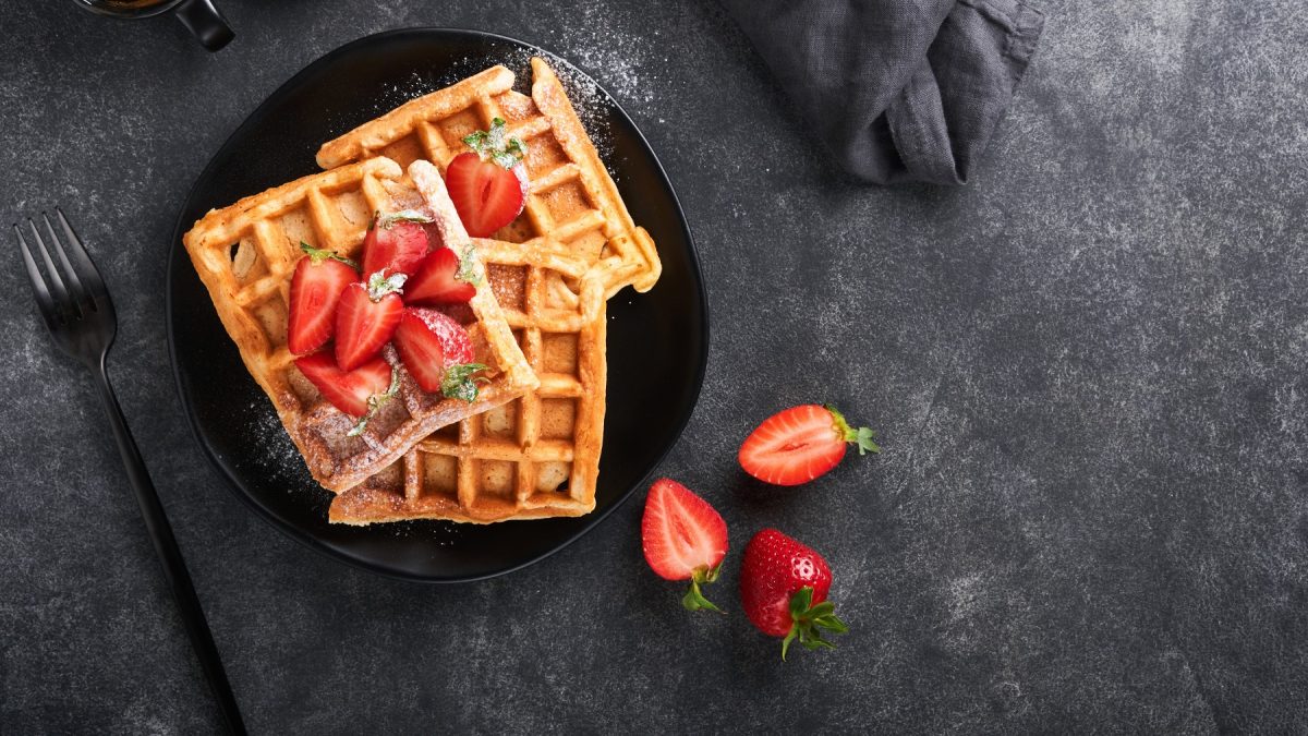 Zuckerfreie Waffeln, mit Puderzucker und Erdbeeren garniert.
