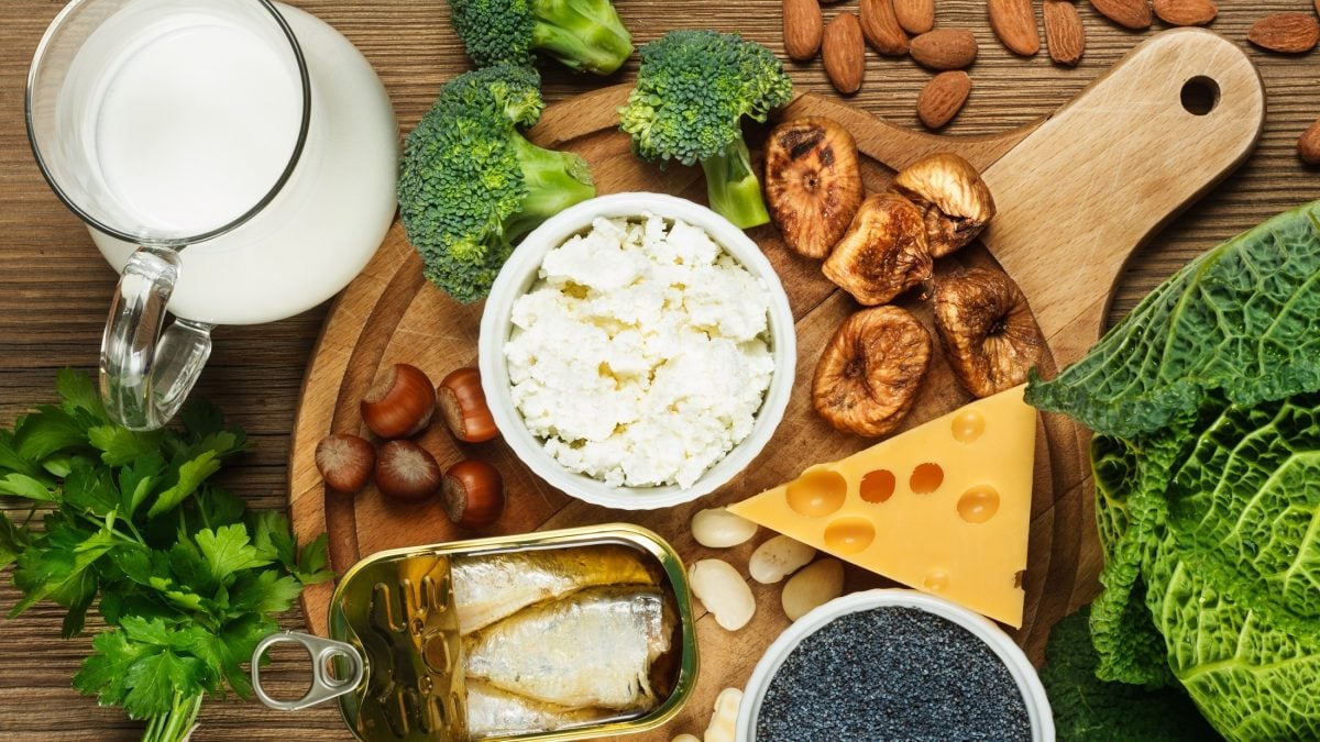 Draufsicht: Ein Untergrund aus Holz, auf dem Lebensmittel mit viel Kalzium, beziehungsweise Calcium, liegen.