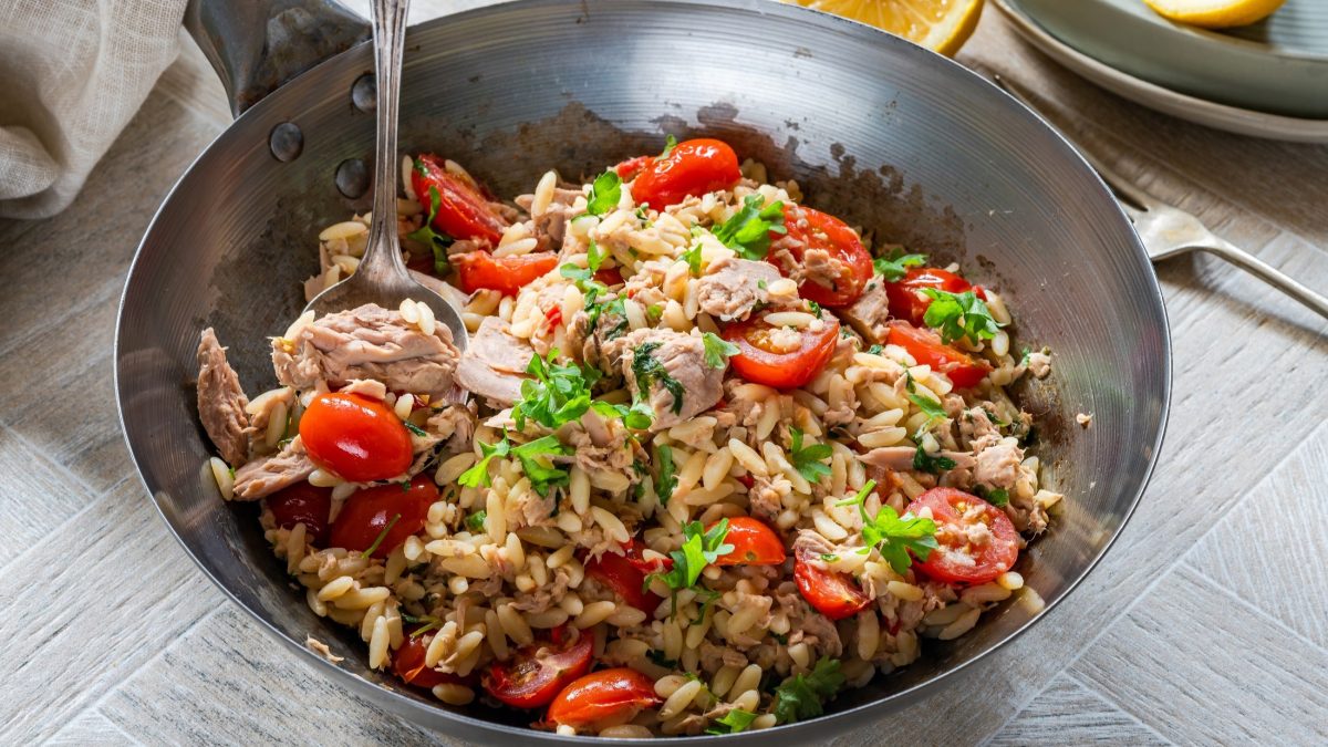 Draufsicht, leicht schräg: eine gusseiserne Pfanne mit einer Orzo-Thunfisch-Pasta.