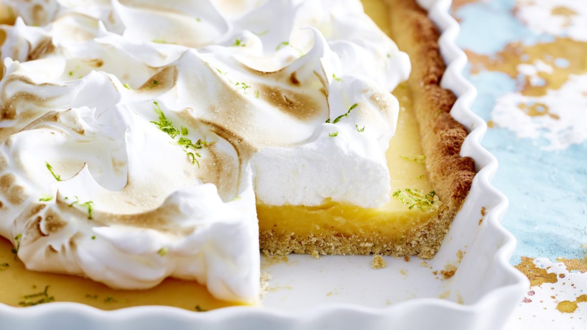 Angeschnittene Key Lime Tarte in weißer Form mit hellem Hintergrund.