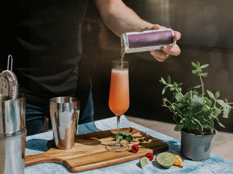 Ein Barkeeper mixt gerade einen Mocktail an einer kleinen Theke.